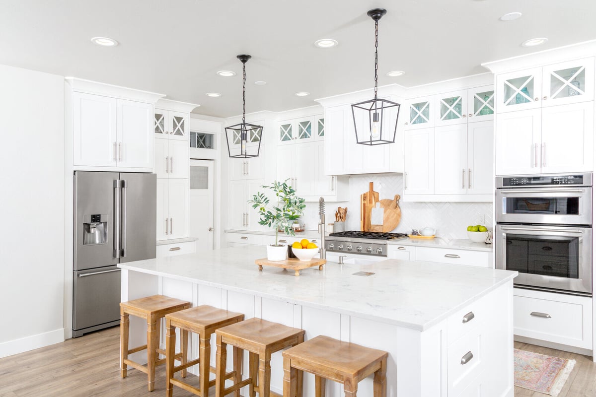 Bright and airy kitchen remodel with a large island and natural wood stools by Triple Crown Contractors in Apex, NC