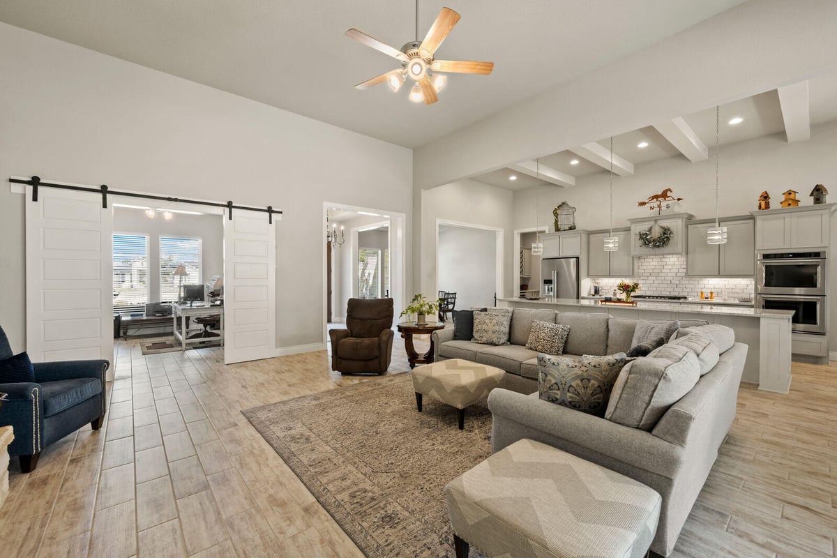 Contemporary farmhouse-style home with an open floor plan, exposed beams, and a modern kitchen, remodeled by Triple Crown Contractors in Apex, NC