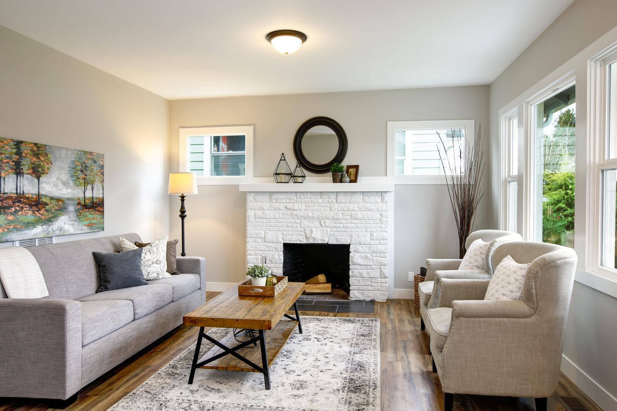 Cozy living room with a white brick fireplace in a whole home remodel by Triple Crown Contractors in Apex, NC