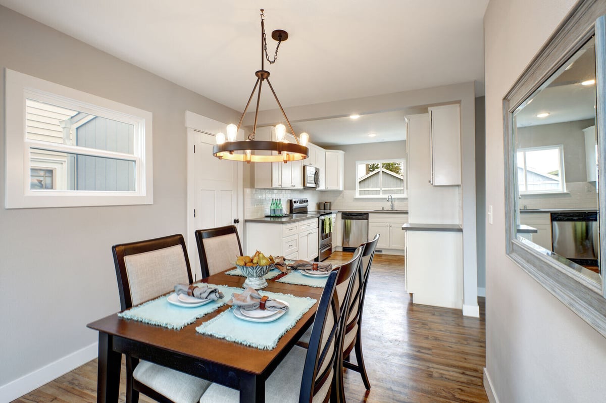 Elegant dining space with a farmhouse-style table and contemporary lighting, renovated by Triple Crown Contractors in Durham, NC