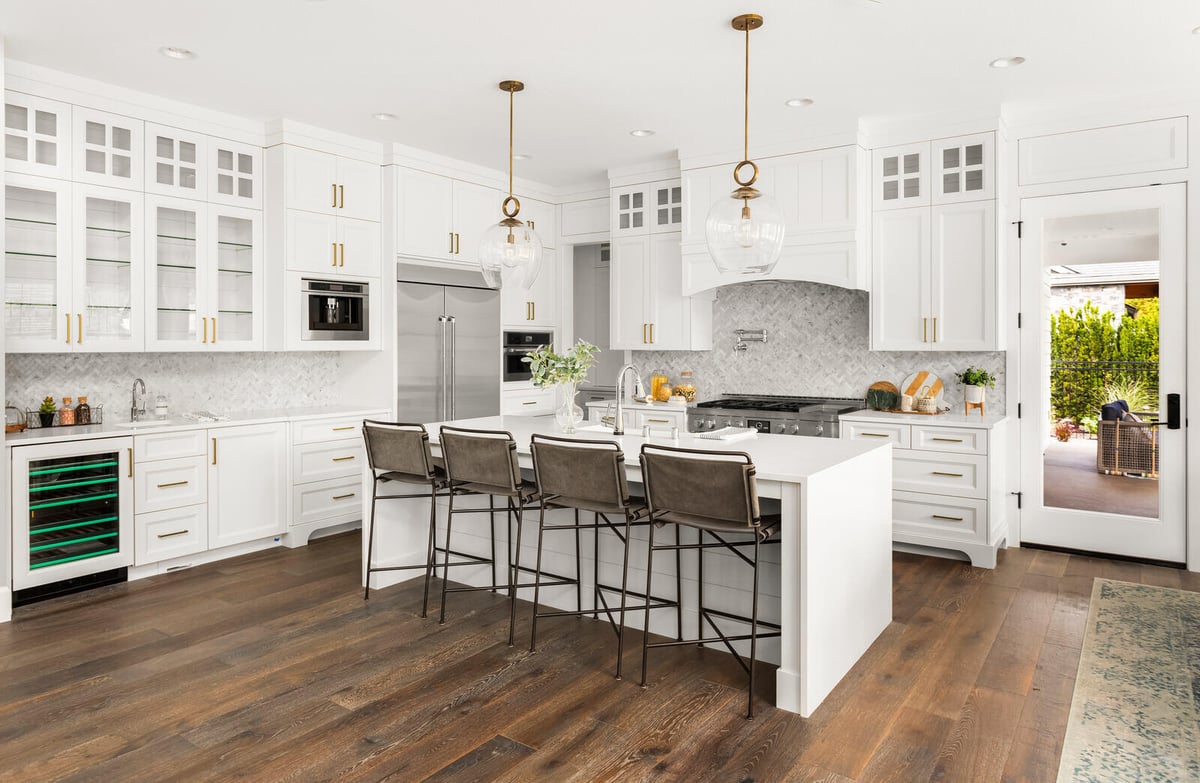 Elegant white kitchen with custom cabinetry and pendant lighting, part of a whole home renovation in Apex, NC