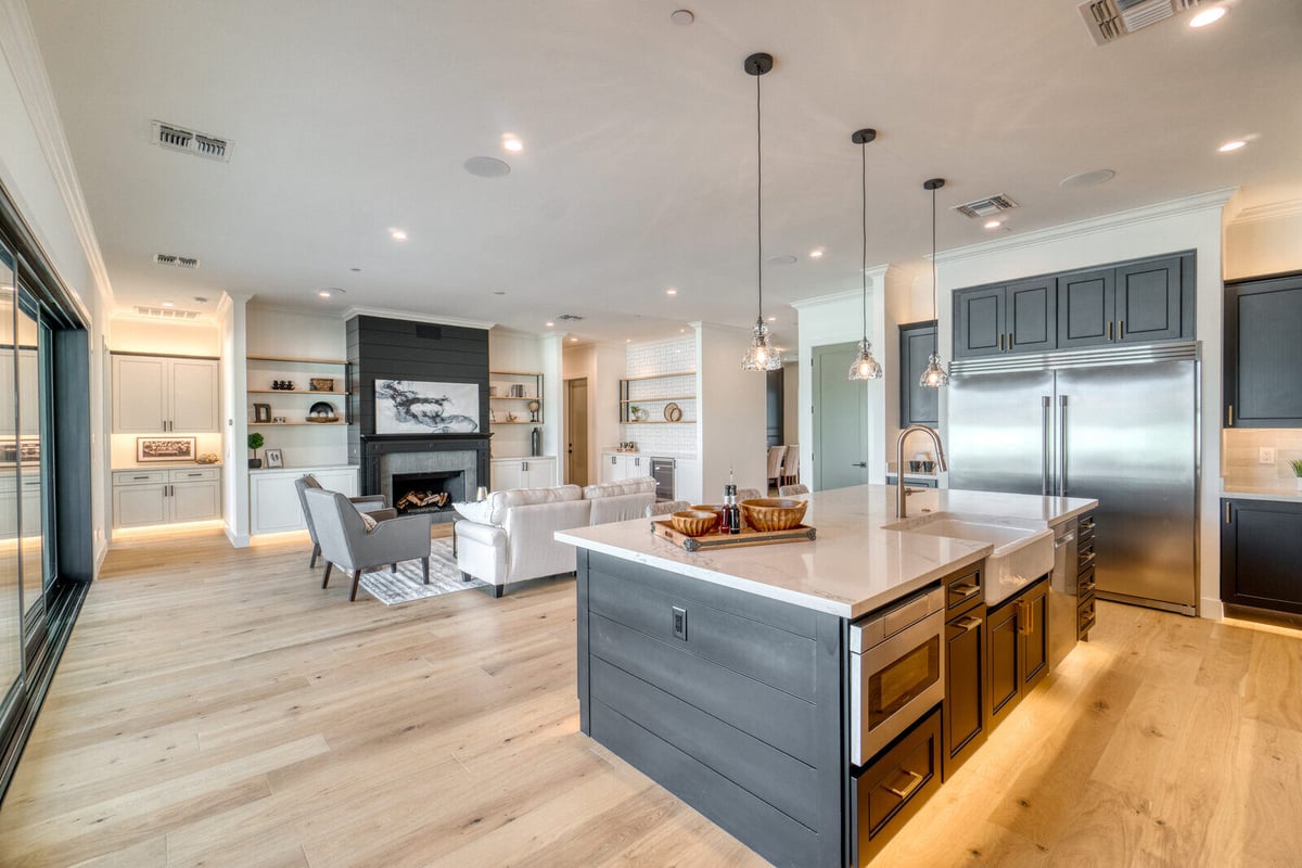 Open-concept kitchen and living area with sleek finishes in a whole home remodel by Triple Crown Contractors in Apex, NC