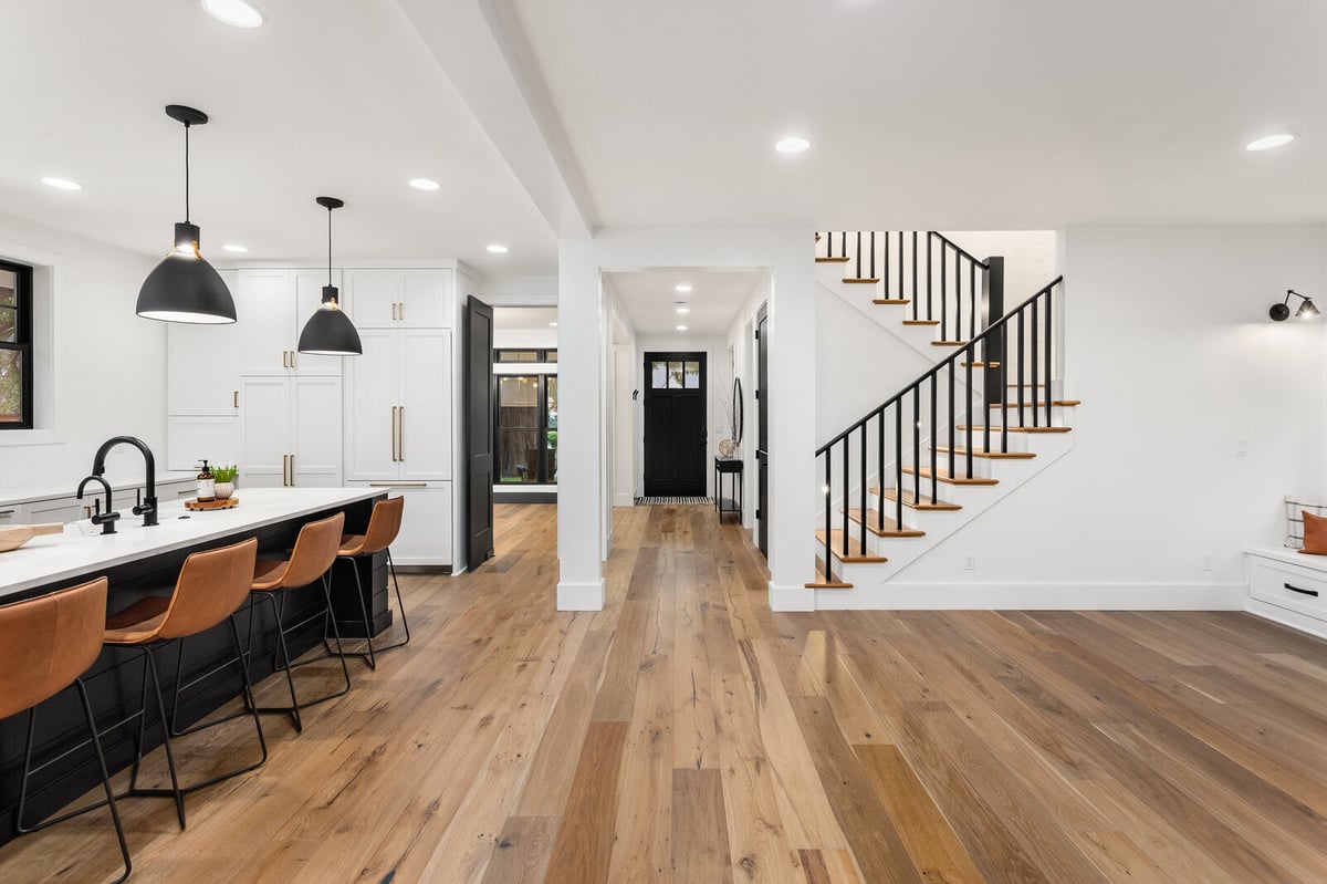Sleek and modern kitchen with black and white cabinetry in a whole home remodel by Triple Crown Contractors in Apex, NC