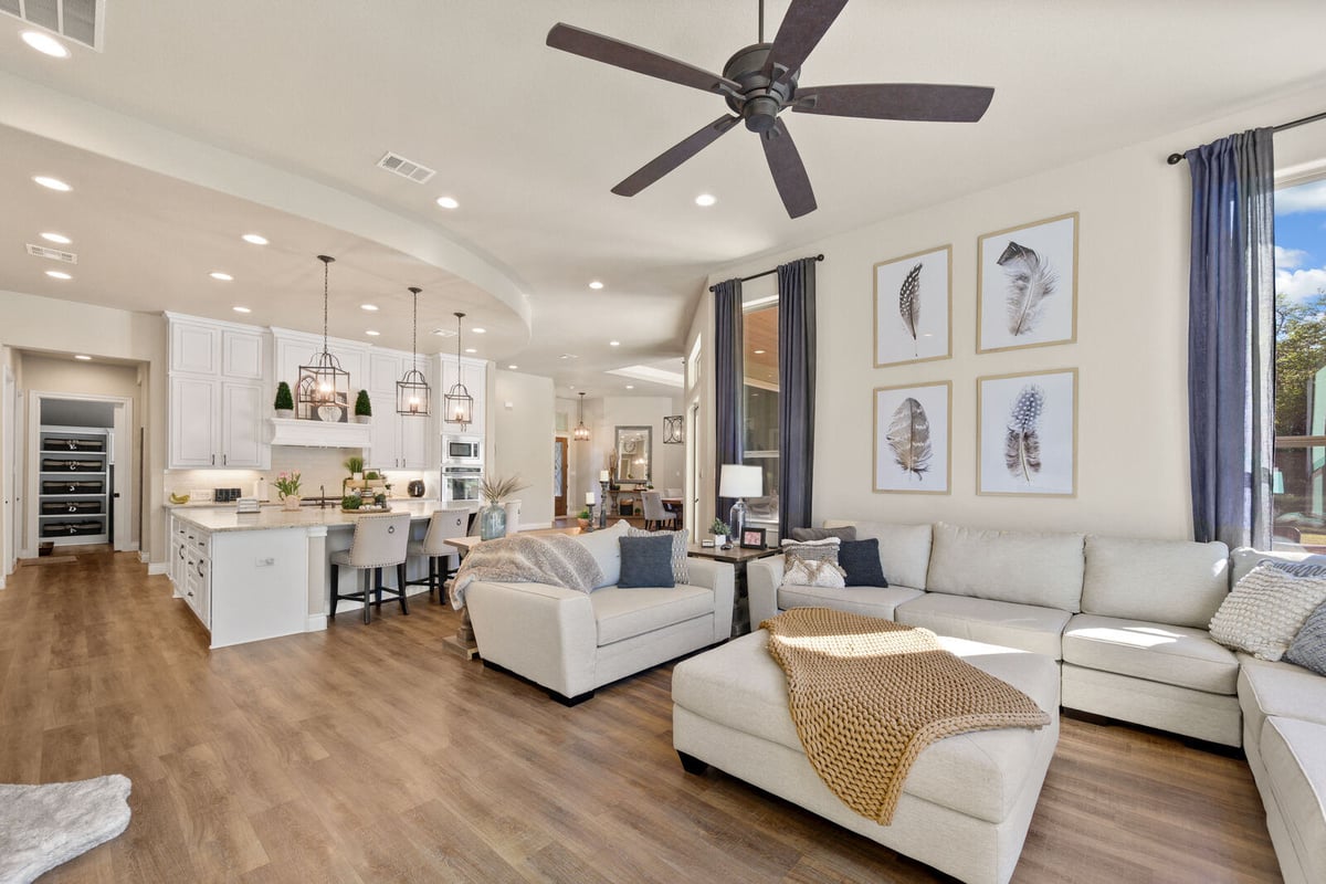 Spacious open-concept living room and kitchen with neutral tones and modern finishes in a home remodel by Triple Crown Contractors in Apex, NC