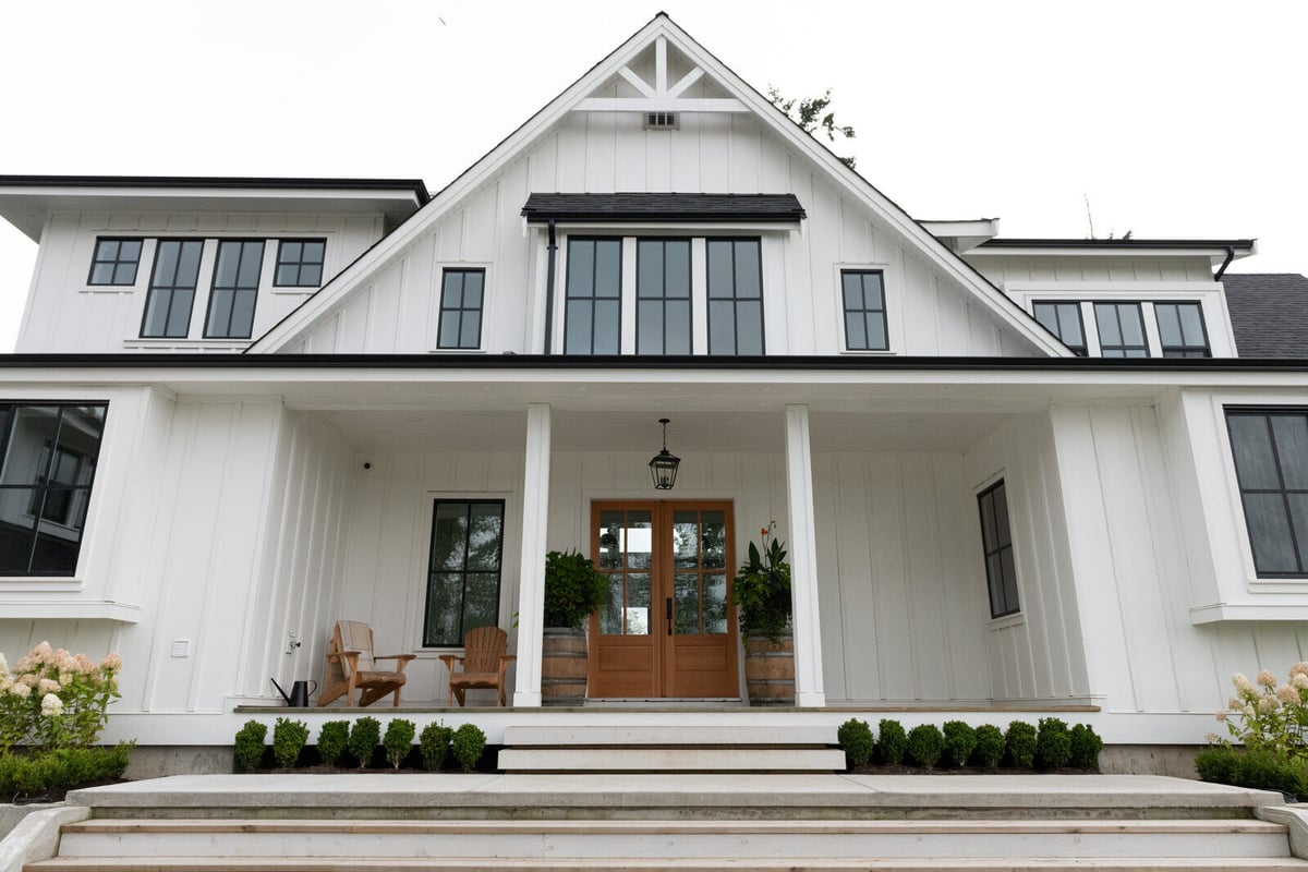 Stunning farmhouse-style home exterior with black-trimmed windows in a custom build by Triple Crown Contractors in Apex, NC